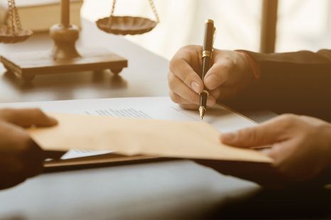 © Wicitr - stock.adobe.com Foto: Person unterschreibt Dokument