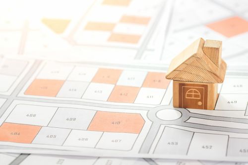 © Puttachat - stock.adobe.com Foto: Katasterplan mit Spielstein Holzhaus